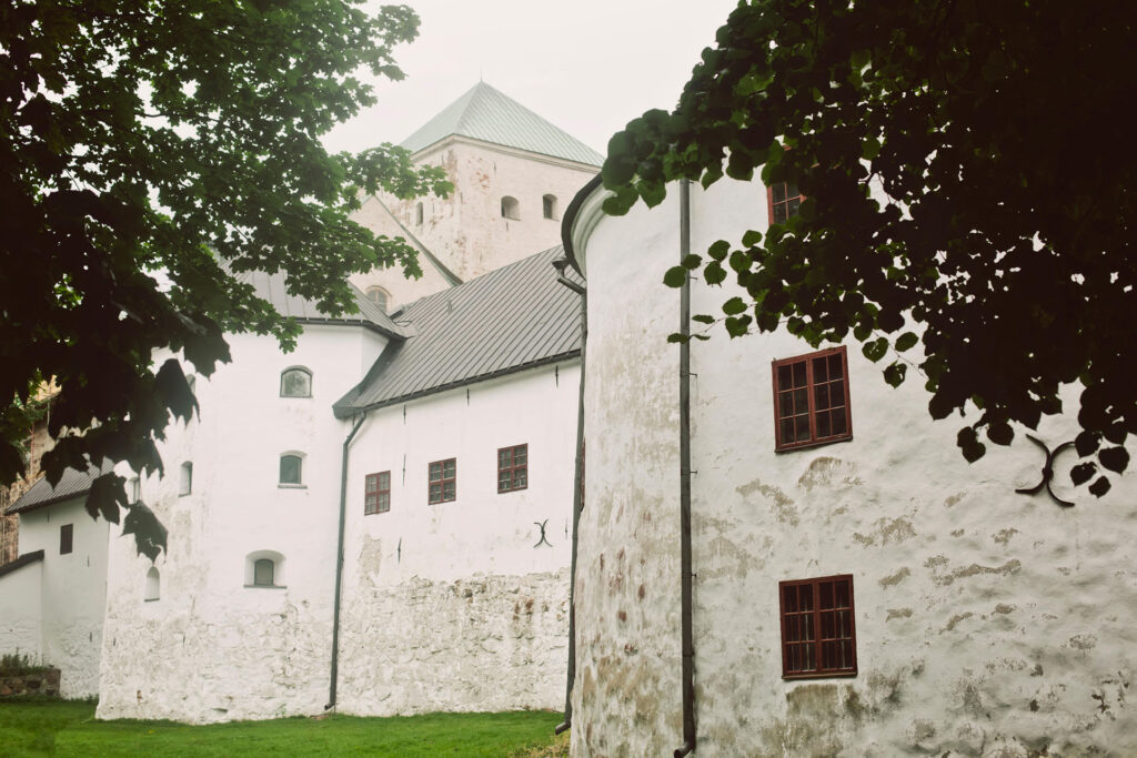 Jylhä vaaleamuurinen esilinna, taustalla päälinnan korkea harmaakivitorni.